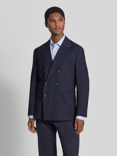 Männermodel trägt Relaxed Fit Anzugsakko mit Viskose-Anteil Modell 'LIAM' von Selected, dunkelblau, zweireihig, Ganzkörperansicht von vorne.