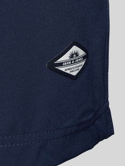 Produktfoto, dunkelblaue Straight Fit Badeshorts mit Logo-Detail Modell 'Maui' von Jack & Jones, elastischer Bund mit Tunnelzug, Textur glatt.