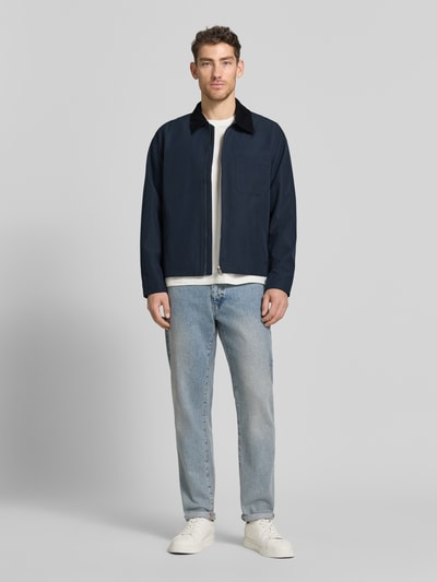 Männermodel trägt Jacke mit Kentkragen in Cord-Optik Modell 'ROBIN' von Samsøe Samsøe, Gerader-Schnitt, Dunkelblau, Ganzkörperansicht von vorne. Kontext: Herren Jacke, Zweiwege-Reißverschluss, Brusttasche, Seitliche Eingrifftaschen, Rückenlänge bei Größe M 63 cm, Schulterbreite 43 cm, Brustweite 58 cm, Ärmellänge 66 cm.