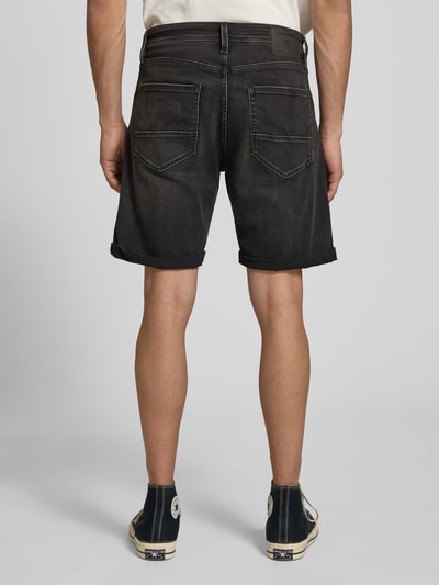 Männermodel trägt Jeansshorts mit Umschlag Modell 'RICK' von Jack & Jones aus Baumwoll-Mix mit Stretch-Anteil, Regular Fit, Ganzkörperansicht Rückansicht.