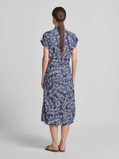 Frauenmodel trägt Hemdblusenkleid aus Viskose mit Brusttaschen von Apricot in Blau mit weißem Blattmuster, Taillierter Schnitt, Bindegürtel, Midikleid, Hemdblusenkragen, Knopfleiste, Ärmel mit fixiertem Aufschlag, Rückenlänge 118 cm, Brustweite 49 cm, Ärmellänge 5 cm, Ganzkörperansicht Rückansicht.