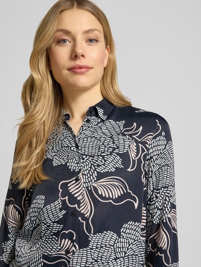 Kobiece model nosi Regular Fit Bluse aus Viskose im Allover-Look od ETERNA, wzór na całej powierzchni, kołnierzyk koszulowy, listwa guzikowa, długość tyłu 73 cm, długość rękawów 64 cm, wiskoza, krój regular fit, bluzka, wzór roślinny w odcieniach granatu, bieli i beżu, Nahaufnahme górnej części ciała.