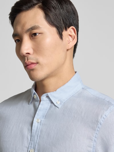 Männermodel trägt Regular Fit Leinenhemd mit Button-Down-Kragen von Scotch & Soda, hellblau, reine Leinenstruktur, Nahaufnahme Oberkörper, Rückenlänge bei Größe M: 76 cm, Schulterbreite: 44 cm, Ärmellänge: 64 cm.