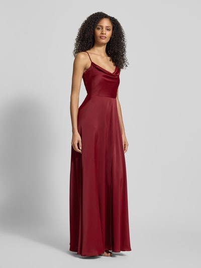 Frauenmodel trägt Abendkleid mit Wasserfall-Ausschnitt von Jake*s Cocktail in Bordeaux, glänzender Material-Mix, Ganzkörperansicht von vorne.