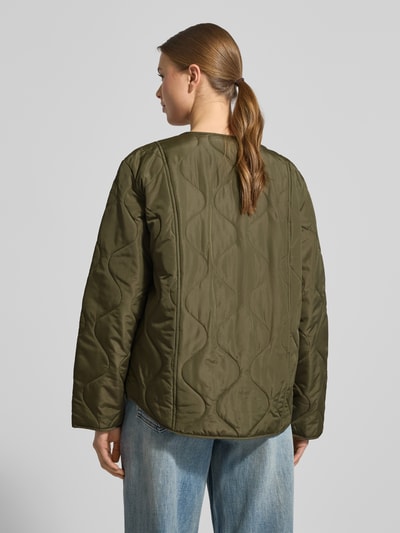 Modelka nosi Kurtka pikowana Regular Fit Steppjacke mit Pattentaschen Modell 'MILLIE' von Vero Moda, efekt: jednolity kolor, krój regular fit, bez kołnierza, długi rękaw, kieszenie z patką, wykończenie: pikowane, całkowity widok z tyłu.