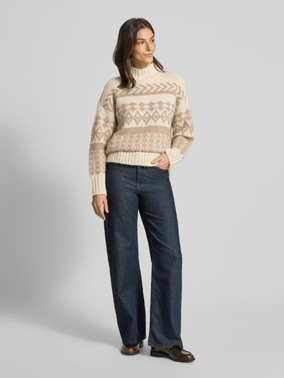 Frauenmodel trägt Comfort Fit Strickpullover aus Norweger-Strick Modell 'AMPLE' von Vero Moda mit Optik:Allover-Muster, Stehkragen, Langarm, geripptem Ärmelabschluss und Rumpfabschluss in Strick-Materialverarbeitung, Cremetöne mit beigen Norweger-Muster, Ganzkörperansicht von vorne.