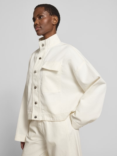Frauenmodel trägt Relaxed Fit Jeansjacke mit Stehkragen von black palms aus Reine Baumwolle in Off-White mit Brusttasche und Knopfleiste, Rückenlänge bei Größe S 58 cm, Ganzkörperansicht von vorne.