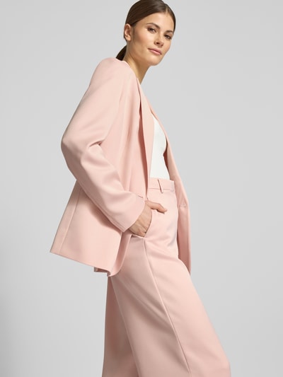Frauenmodel trägt Wide Fit Stoffhose mit Gesäßtasche von Jake*s Collection in zartem Rosa, glatte Textur, Nahaufnahme Oberkörper.