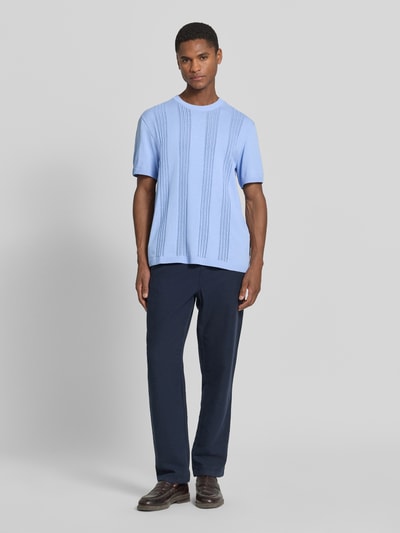 Männermodel trägt Relaxed Fit T-Shirt aus reiner Baumwolle von Armedangels, Optik: Unifarben, Feinstrick, Label-Patch, Ganzkörperansicht von vorne.