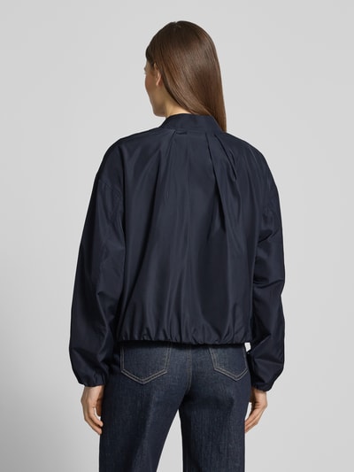 Männermodel trägt Jacke mit Reißverschlusstaschen von Fuchs Schmitt, krój regular fit, granatowy kolor, widoczne kieszenie na zamek, długość tyłu w rozmiarze 36: 52 cm, szerokość ramion w rozmiarze 36: 54 cm, szerokość klatki piersiowej w rozmiarze 36: 57 cm, długość rękawa w rozmiarze 36: 53 cm, całkowity widok z tyłu