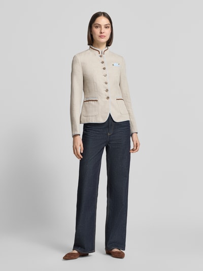 Modelka nosi Slim Fit Blazer aus Leinen-Baumwoll-Mix von WHITE LABEL, mieszanka lnu i bawełny, krój slim fit, stójka, listwa guzikowa, nakładane kieszenie, długość tyłu w rozmiarze 36: 58 cm, szerokość w rozmiarze 36: 46 cm, długość rękawów w rozmiarze 36: 63 cm, jasny beż, tekstura gładka, widoczne guziki, ciemnoniebieskie spodnie, brązowe buty, pełen widok od przodu