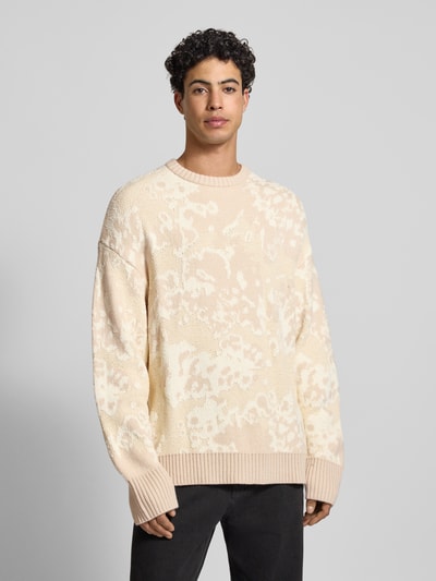 Männermodel draagt Oversized Strickpullover mit gerippten Abschlüssen van G-star, katoenmix met wol, ribboorden, ronde hals, heren, oversized, kleur lichtbeige met patroon, productcontext, Ganzkörperansicht von vorne.