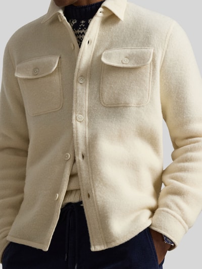 Männermodel trägt Oversized Hemdjacke aus Woll-Mix von Polo Ralph Lauren in Creme mit Brusttaschen, Knopfleiste, Nahaufnahme Oberkörper.