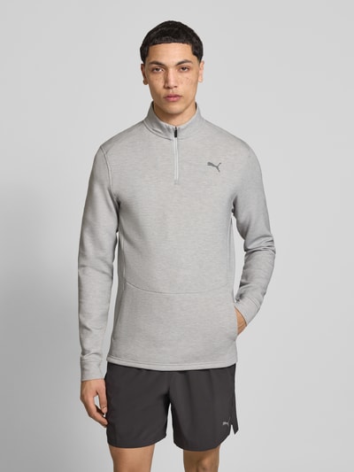 Männermodel trägt Sweatshirt mit Label-Detail Modell 'CLOUDSPUN' von PUMA PERFORMANCE im Elastischer-Material-Mix mit Lyocell-Anteil, Gerader-Schnitt, Troyer-Kragen, Rückenlänge 74 cm, Ärmellänge 74 cm, Grau, glatte Textur, Ganzkörperansicht von vorne.