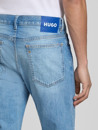 Mężczyznamodel nosi Straight Fit Jeans aus Baumwolle od HUGO, efekt: jednolity kolor, krój straight fit, detal z logo, 5 kieszeni, zapięcie na guzik i zamek błyskawiczny, średni stan, bawełna. Detailaufnahme.