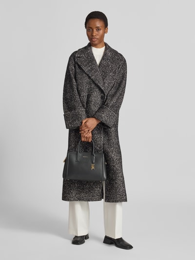 Frauenmodel trägt Handtasche aus Leder mit Label-Applikation Modell 'LAILA' von MICHAEL Michael Kors in Schwarz, Ganzkörperansicht von vorne.
