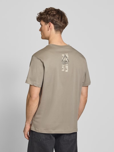 Männermodel trägt T-Shirt aus Baumwolle mit Rundhalsausschnitt von G-Star Raw in Beige, Regular Fit, glatte Textur, Rückendruck, Ganzkörperansicht Rückansicht.