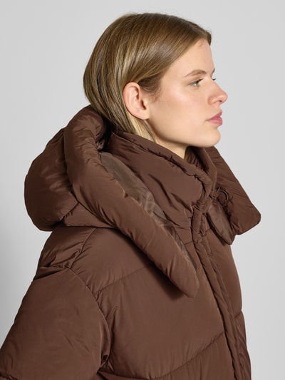 Frauenmodel trägt Regular Fit Steppjacke mit Kapuze Modell 'CORNELIA' von Only, unifarben braun, Nahaufnahme Oberkörper.