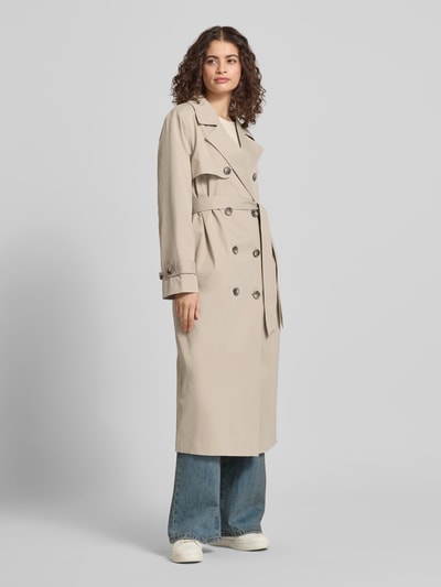 Modelka nosi Regular Fit Trenchcoat mit Reverskragen Modell 'DISA LIFE' od Only, jednolity beż, długi rękaw, pasek, przednie kieszenie, widok całej sylwetki z przodu.