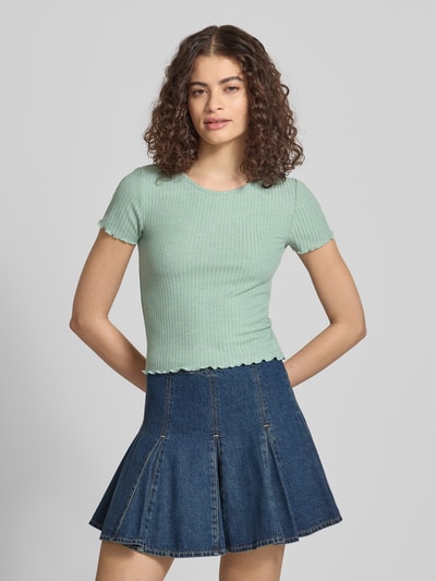 Frauenmodel trägt Slim Fit T-Shirt mit Viskose-Anteil Modell 'EMMA' von Only, Optik: Unifarben, Struktur-Muster, Rundhals-Ausschnitt, Kurzarm, Ärmelabschluss: Frill, Rumpfabschluss: Frill, Materialverarbeitung: Jacquard Stretch, Material-Mix mit Viskose-Anteil, sanftes Mintgrün, feine Rippenstruktur, Ganzkörperansicht von vorne.