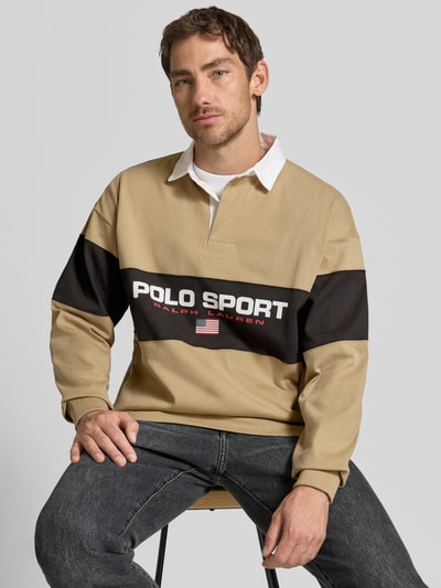 Männermodel trägt Relaxed Fit Poloshirt aus reiner Baumwolle von Polo Ralph Lauren, beż, czerń, biel, prosty fason, nadruk z logo, Nahaufnahme Oberkörper