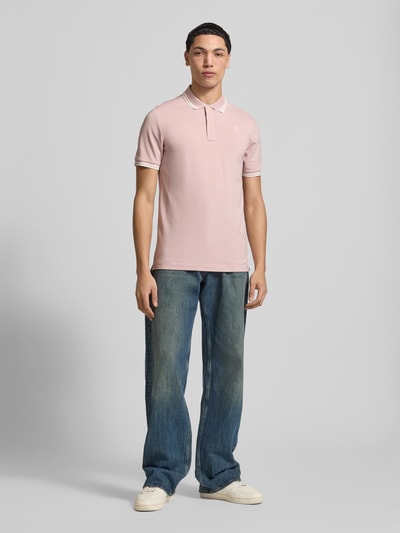 Mannelijk model draagt Slim Fit Poloshirt met Logo-Stitching Model 'Dunda' van G-Star Raw in lichtroze katoenmix, slim fit, polokraag, ruglengte maat M 72 cm. Ganzkörperansicht van voren.