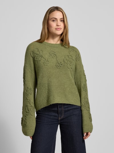Frauenmodel trägt Strickpullover mit Stitchings Modell 'Miabelle Hope' von MSCH Copenhagen in Olivgrün, Relaxed Fit, Nahaufnahme Oberkörper.