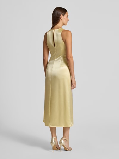Frauenmodel trägt Cocktailkleid aus Satin mit Motiv-Print von YAS in Gold, A-Linie, Midikleid, Ganzkörperansicht Rückansicht. Rückenlänge bei Größe 36: 124 cm, Brustweite bei Größe 36: 42 cm, Modell 'ORCHIDA', Rundhalsausschnitt, glatte Satin-Optik, Damen Cocktailkleider.