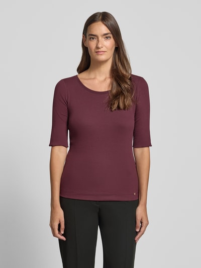 Frauenmodel trägt T-Shirt mit Rundhalsausschnitt und Label-Detail von Marc Cain, Baumwoll-Elasthan-Mix, Slim-Fit, dunkelrot, Ganzkörperansicht von vorne. Damen T-Shirt, Ärmel mit Aufschlag, Rückenlänge bei Größe 36: 55 cm.