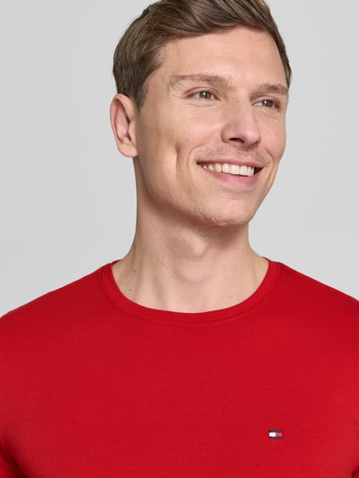 Männermodel trägt Slim Fit T-Shirt aus Baumwoll-Mix von Tommy Hilfiger in Rot, unifarben mit Logo-Detail, Nahaufnahme Oberkörper