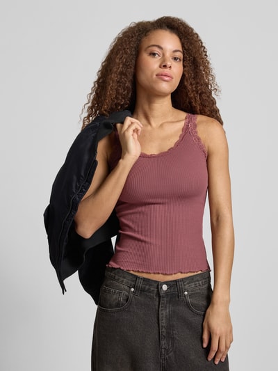 Frauenmodel trägt Slim Fit Tank Top aus Bio-Baumwoll-Mix Modell 'SARA' von Only in Optik: Unifarben mit Spitze und U-Ausschnitt, Feinripp-Struktur in Altrosa, schmale Träger, Nahaufnahme Oberkörper.