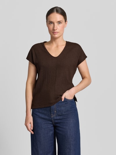 Modelka nosi damski t-shirt z elastycznej mieszanki materiałów, taliowany krój, fakturowany wzór, głęboki okrągły dekolt, model 'Sirukus' od OPUS, długość tyłu w rozmiarze 36: 50 cm, kolor brązowy, prosta tekstura, widok całej sylwetki z przodu.