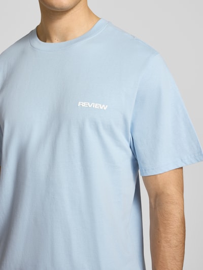 Männermodel trägt T-Shirt mit Logo und Rundhalsausschnitt von REVIEW in Hellblau, Regular-Fit, Baumwoll-Viskose-Mix, Nahaufnahme Oberkörper. Rückenlänge bei Größe M 64 cm.