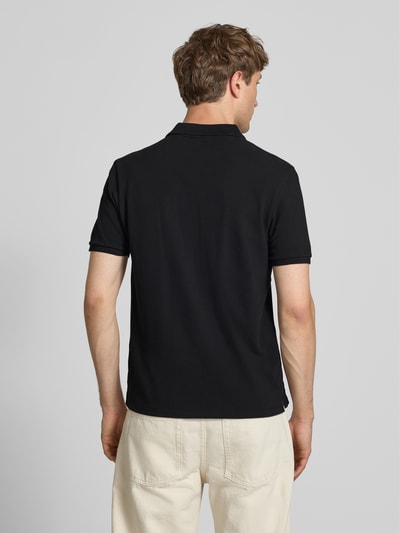 Männermodel trägt schwarzes Modern Fit Poloshirt mit Logo-Stitching von REVIEW aus Baumwoll-Mix, Rückenlänge 65 cm, Ganzkörperansicht Rückansicht.