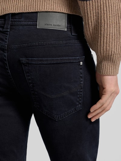 Mężczyzna nosi Jeansy Tapered Fit z detalem z logo Model 'Lyon' od Pierre Cardin, mieszanka bawełny z dodatkiem streczu, detal z logo, zbliżenie tylnej części.