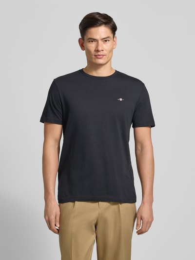 Männermodel trägt Regular Fit T-Shirt mit Label-Stitching Modell 'SHIELD' von GANT, Unifarbenes-Design, Reine Baumwolle, Rundhalsausschnitt, Rückenlänge 65 cm, Ganzkörperansicht von vorne.