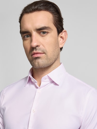 Männermodel trägt Slim Fit Business-Hemd mit Kentkragen und extra langem Ärmel von Jake*s, Material-Mix mit Stretch-Anteil, Nahaufnahme Oberkörper.
