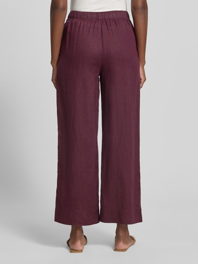 Frauenmodel trägt Stoffhose mit elastischem Bund Modell 'LINO' von Mango aus Material-Mix mit Baumwoll-Anteil, Wide-Leg, Ganzkörperansicht Rückansicht.