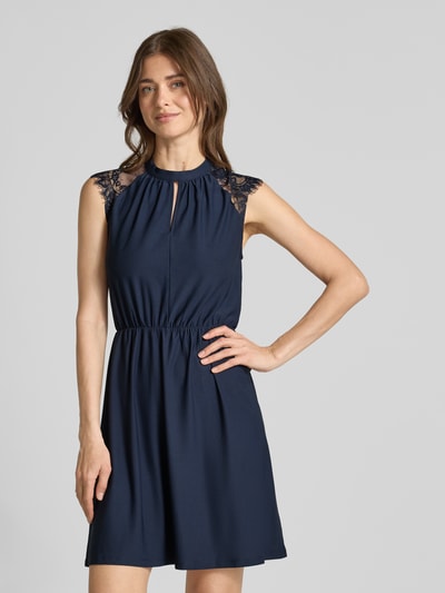 Frauenmodel trägt Tailliertes Freizeitkleid mit Spitzenbesatz Modell 'MILLA' von Vero Moda, Optik: Unifarben, Mini-Länge, Hochgeschlossen, Kurzarm, Materialverarbeitung: Stretch, Ganzkörperansicht von vorne.