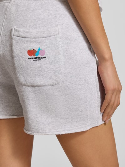 Kobiece modelka nosi Sweatshorts mit elastischem Bund Modell 'TUBAY' von American Vintage, jasnoszary bawełniano-elastanowy materiał, prosty krój, kieszeń tylna, kieszenie boczne, długość nogawki 9 cm w rozm. S, zdjęcie z bliska tyłu.