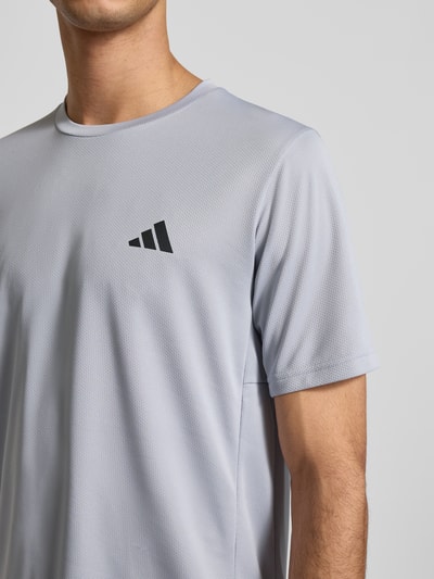 Męski t-shirt Regular Fit T-Shirt mit Logo-Print od adidas Training w kolorze jasnoszarym, fakturowany wzór, okrągły dekolt, nadruk z logo, długość tyłu w rozmiarze M: 70 cm, nahaufnahme górnej części ciała.