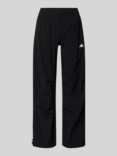 Produktfoto, Wide Fit Stoffhose mit Logo-Print von adidas Sportswear, schwarz, weiter Schnitt, elastischer Bund, glatte Textur, frontal.