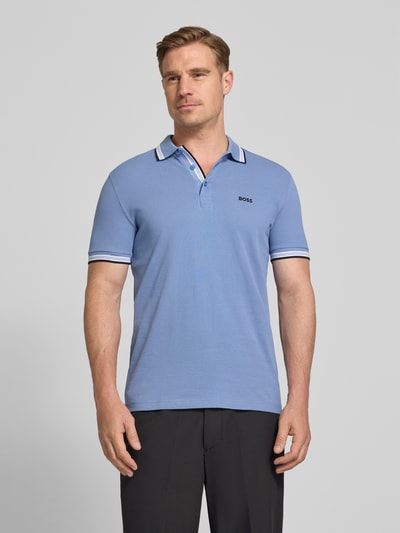 Męski model nosi Regular Fit Poloshirt aus reiner Baumwolle Modell 'PADDY' od BOSS Green, kolor jednolity, krój regular fit, bawełniany piqué, detal z logo, polokołnierzyk, trzy guziki, krótkie rękawy; widok całej sylwetki z przodu.