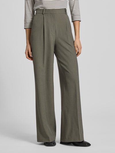 Frauenmodel trägt Wide Fit Bundfaltenhose mit Viskose-Anteil Modell 'Napoli' von Mango in Oliv mit Bügelfalten, Nahaufnahme Unterkörper.