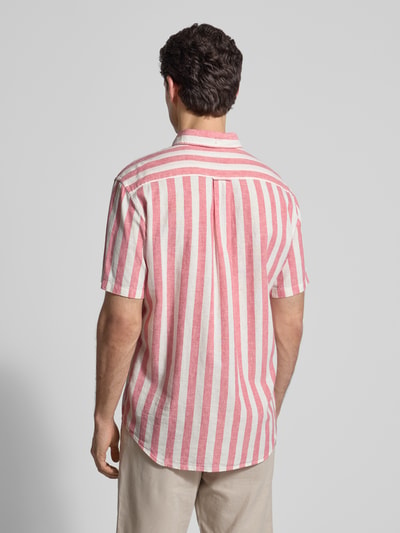 Männermodel trägt Regular Fit Freizeithemd aus Leinen-Baumwoll-Mix von Gant, rot-weißes Streifenmuster, halbarm, Ganzkörperansicht Rückansicht.