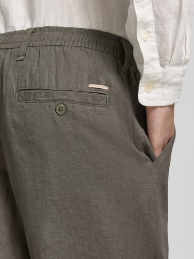 Männermodel trägt Leinenhose mit Eingrifftaschen Modell 'KARL LAWRENCE' von Jack & Jones Premium in Olive, Nahaufnahme Gesäßbereich. Reines Leinen, Straight Fit, elastischer Bund, Knopf-Reißverschluss, französische Eingrifftaschen, Gesäßleistentaschen, Bundweite 42 cm, Innenbeinlänge 75 cm, Größe M.