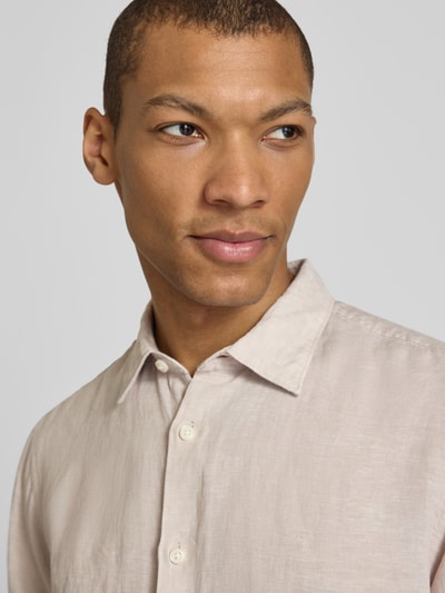 Männermodel trägt Regular Fit Freizeithemd aus reinem Leinen Modell 'REGKYLIAN' von SELECTED HOMME, unifarben, Nahaufnahme Oberkörper.