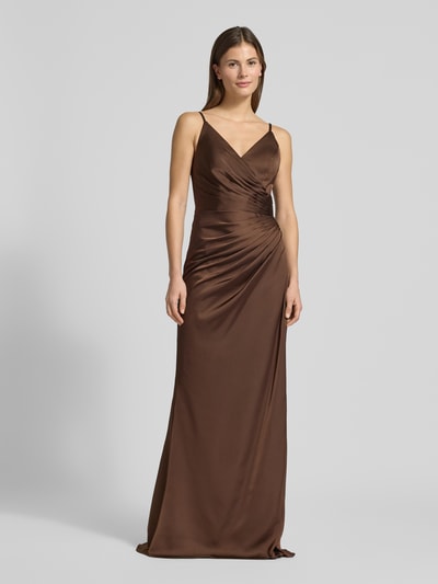 Frauenmodel trägt Abendkleid aus Satin in Wickel-Optik von Mascara, Braun, eng anliegende Passform, Spaghettiträger, Maxilänge, Ganzkörperansicht von vorne.