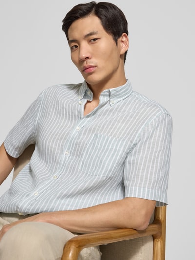 Männermodel trägt Regular Fit Freizeithemd aus Leinen von Christian Berg Men, weiß mit hellblauen Streifen, Nahaufnahme Oberkörper.