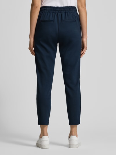 Männermodel trägt Sweatpants mit Ziernähten Modell 'RIZET' von b.young, granatowy, luźny krój, elastyczny pas, widok całej sylwetki z tyłu.